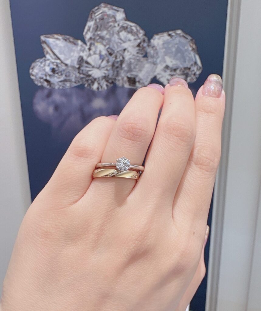 ロイヤル・アッシャー プラチナの婚約指輪251と、イエローゴールドの結婚指輪921を重ねてつけた手元の画像