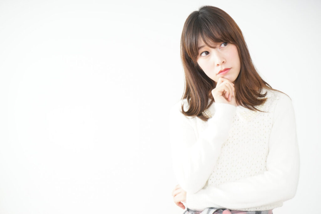 首を傾げて考え込んでいる女性
