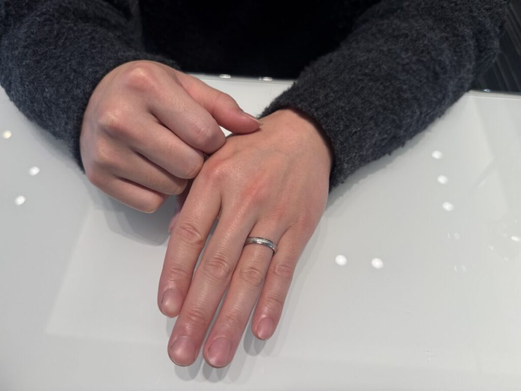 つや消しの結婚指輪をつけている男性の手元