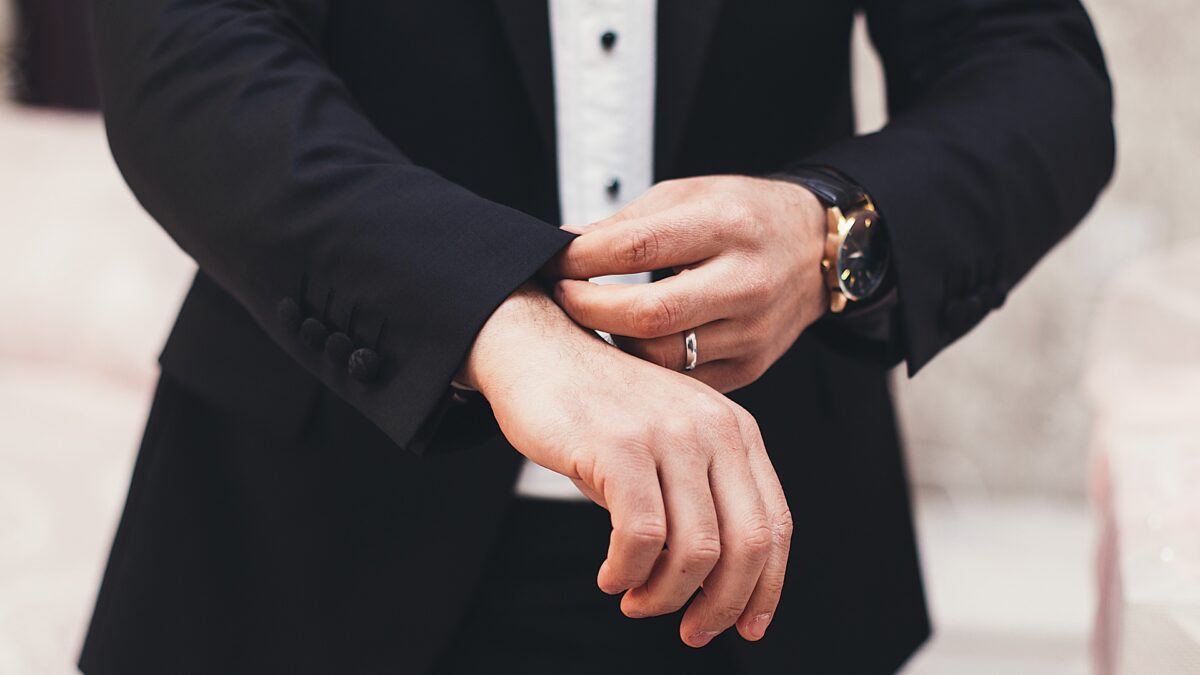 スーツを着て結婚指輪をつけている人の手元