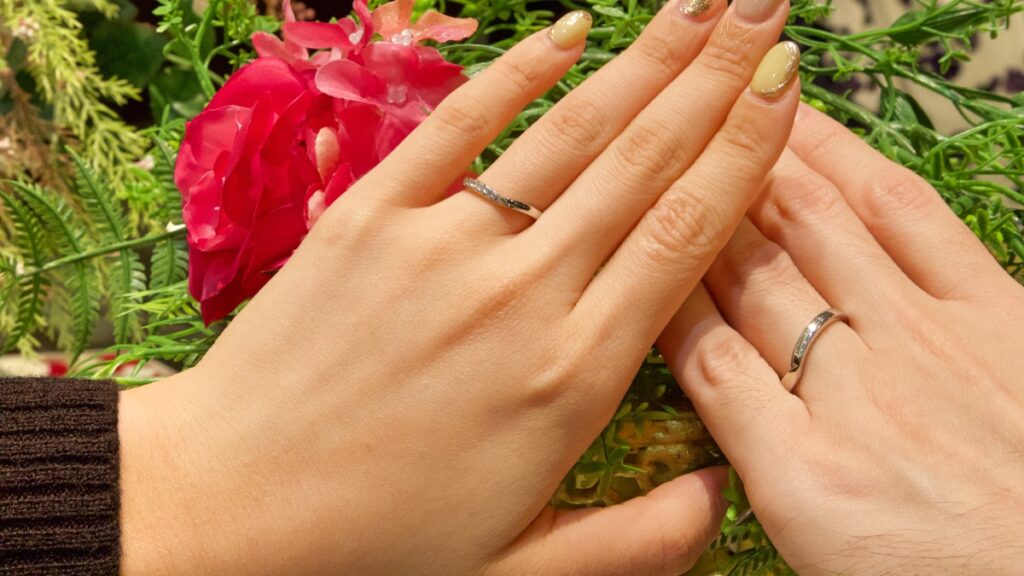 結婚指輪を薬指に身につけた男女の手元の画像