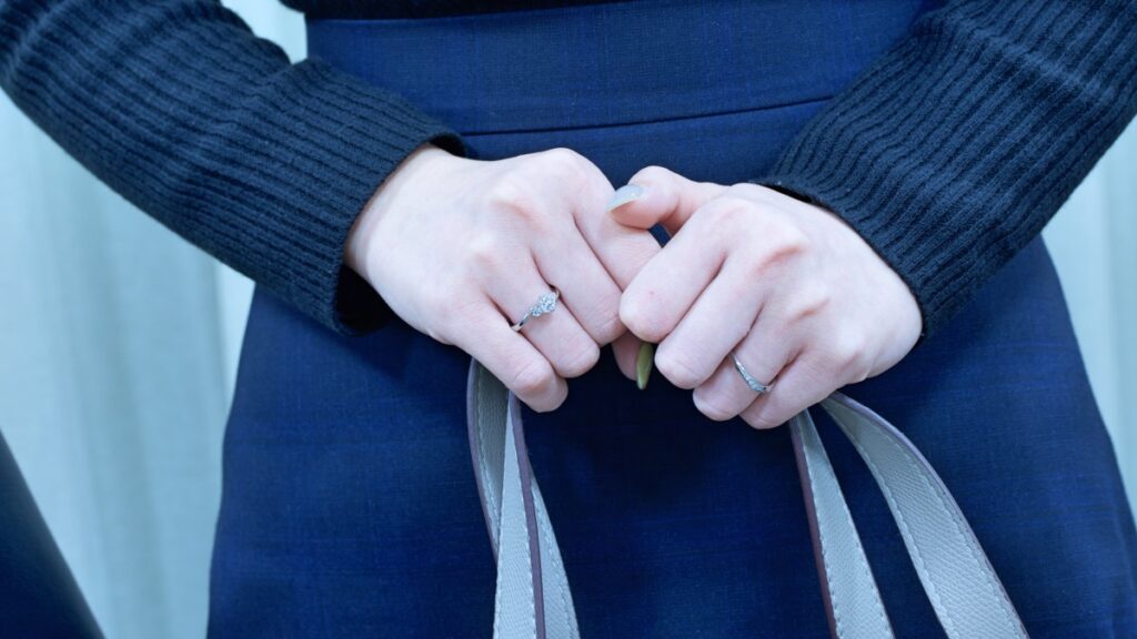 婚約指輪をぎゅっと握った手元