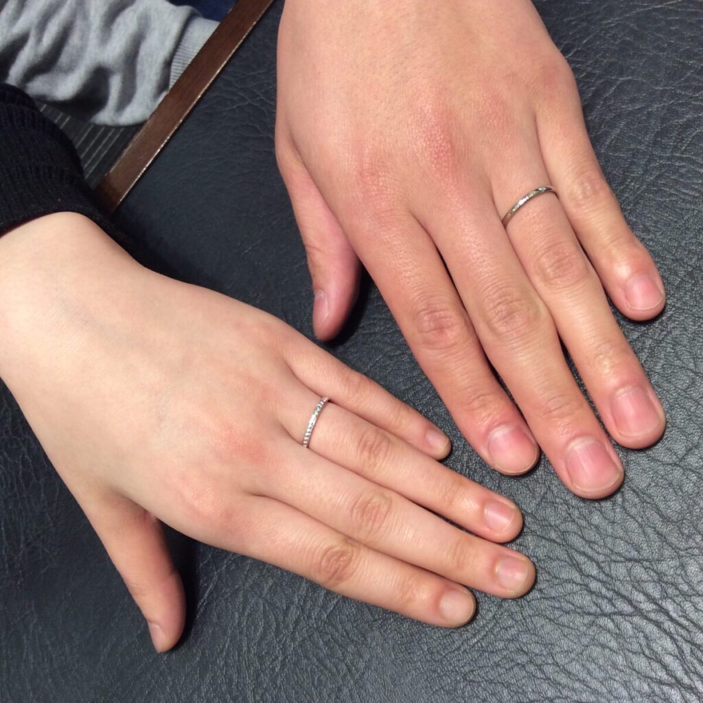 NIWAKAの結婚指輪　ことほぎとかれんを着けている手元の写真