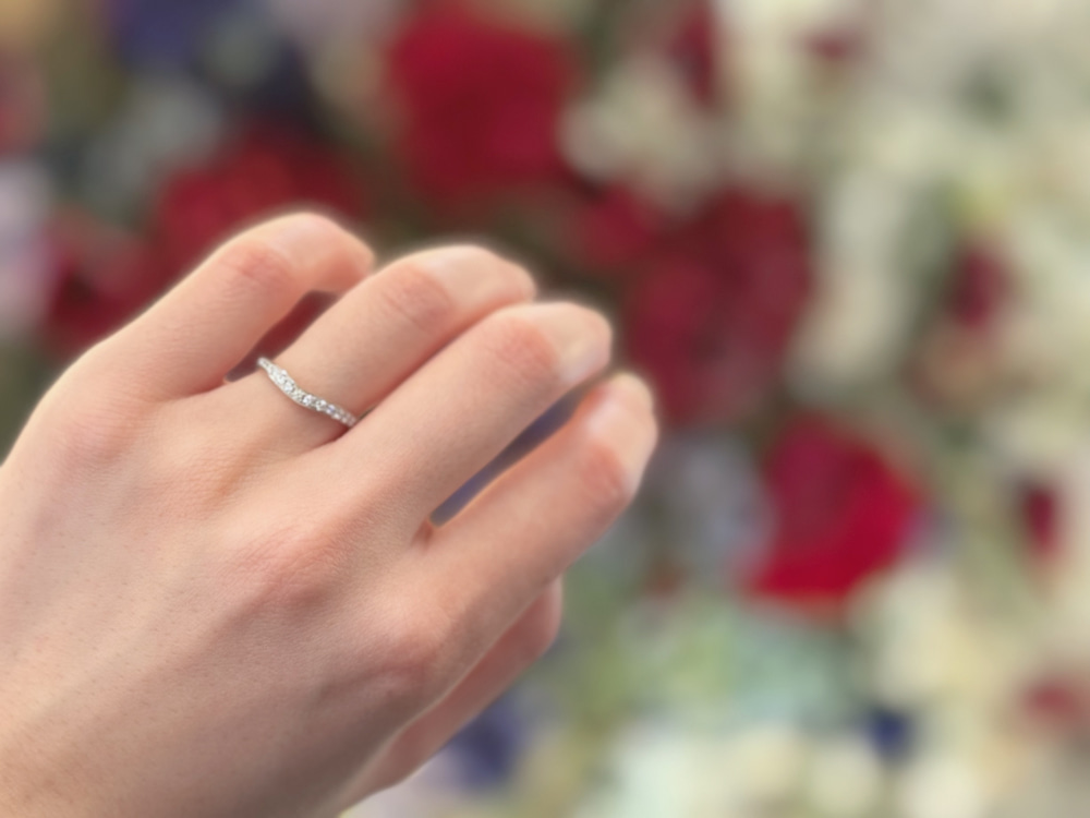 V字のエタニティリングをつけた手元