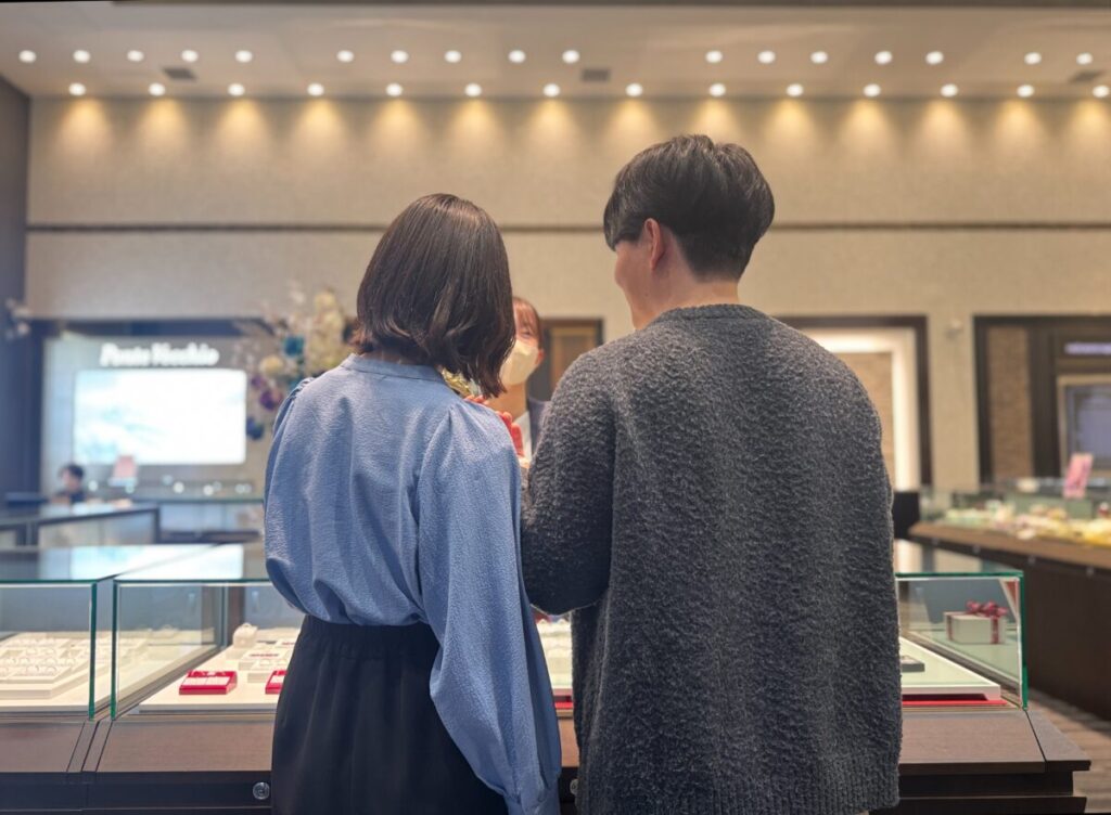 セレクトショップの店内で結婚指輪を見比べるカップル
