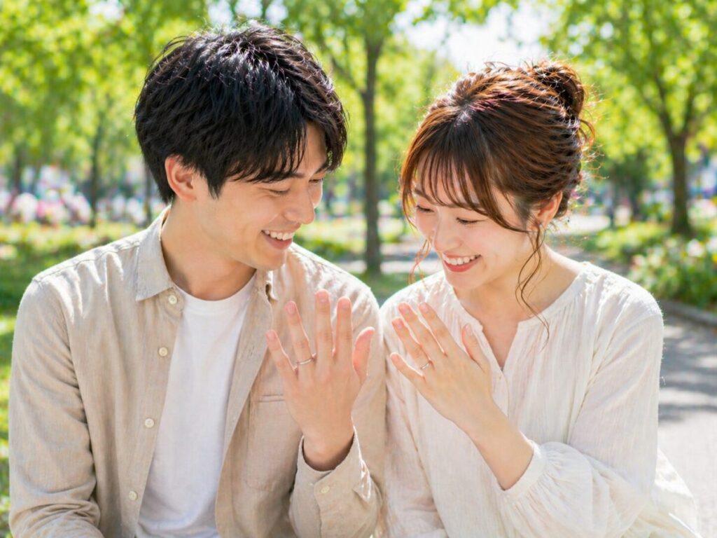 楽しそうに結婚指輪をみるカップル