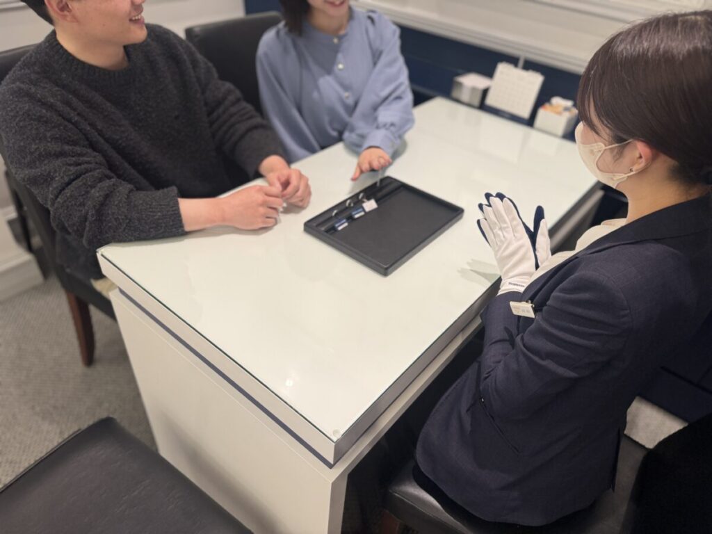 ショップで結婚指輪の相談をするカップル