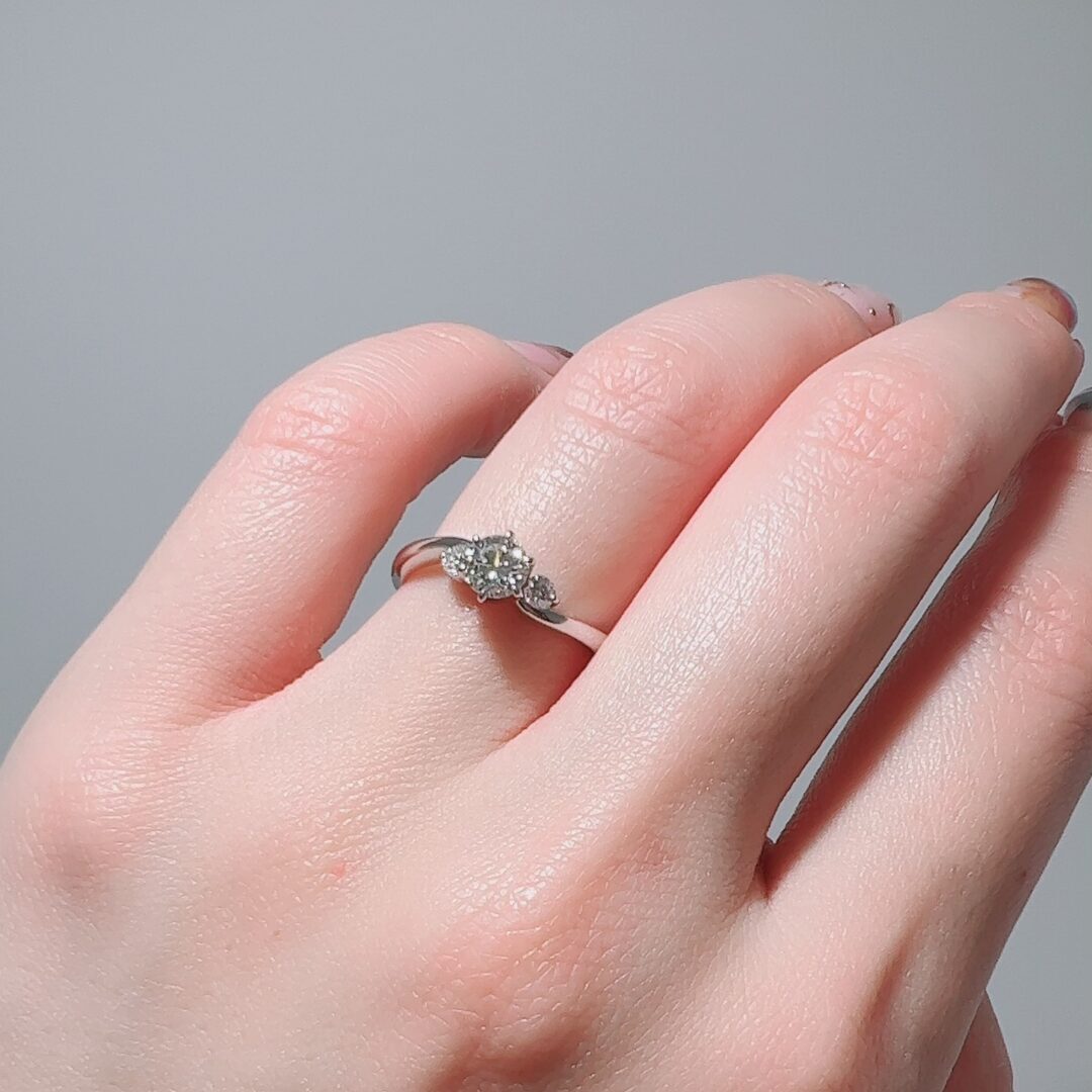 ウェーブ3石の婚約指輪をつけた手元
