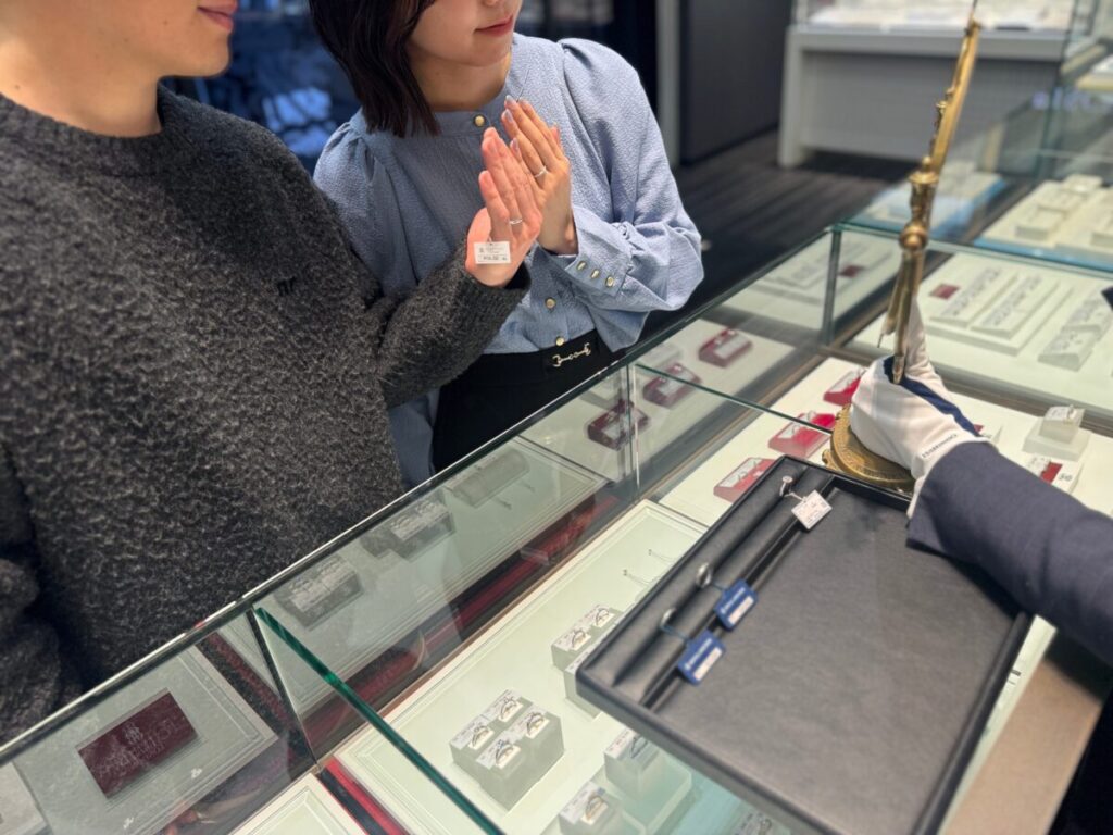 鏡を見ながら結婚指輪を試着しているカップル