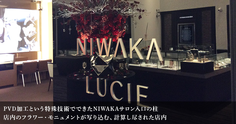 PVD加工という特殊技術でできたNIWAKAサロン入口の柱 店内のフラワー・モニュメントが写り込む、計算し尽された店内